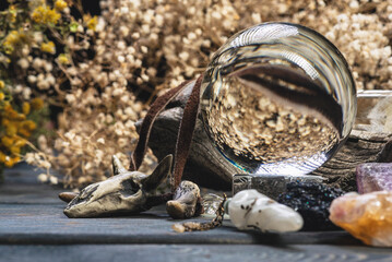 Crystal ball and magical stones on the old wooden table close up background.