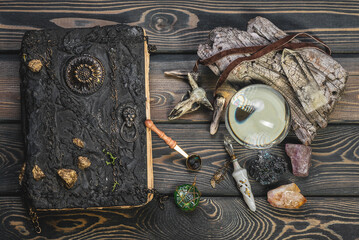 Crystal ball, spell book, magic potion on the old wooden table background concept.