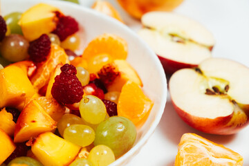 Fruit salad with sliced fruit, mixed grapes, raspberries, nectarines, tangerines and apples