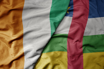 Fototapeta premium big waving national colorful flag of cote divoire and national flag of central african republic .