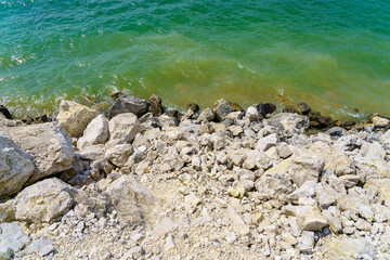 Obraz premium Rocky shore of a fresh reservoir. Background with selective focus and copy space