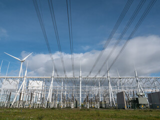 Electricity generator transformator at power plant and power lines pylons