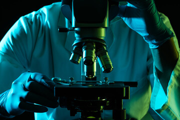 Scientist using microscope and copy space on black background