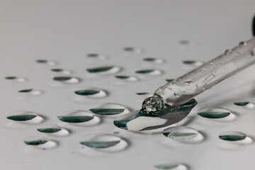 Close up of pipette with drops and copy space on grey background