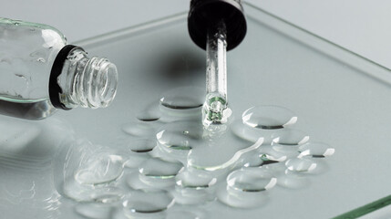 Close up of bottle and pipette with drops and copy space on grey background