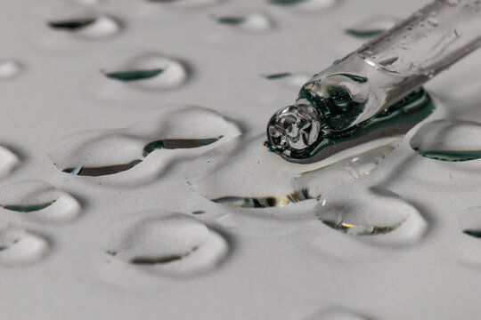 Close up of pipette with drops and copy space on grey background