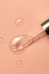 Close up of pipette with drops and copy space on pink background