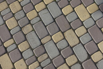 Texture of yellow, brown and grey colored concrete pavement