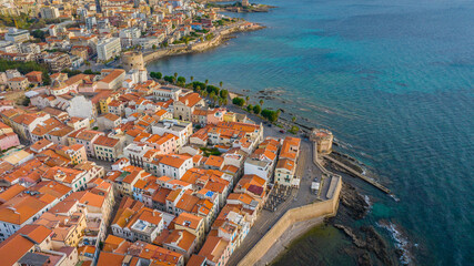 Fototapeta na wymiar Aerial view of the old town of Alghero in Sardinia. Photo taken with a drone on a sunny day. Panoramic view of the old town and harbor of Alghero, Sardinia, Italy.