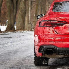 Modern red sport car in the winter forest background,  car wallpaper