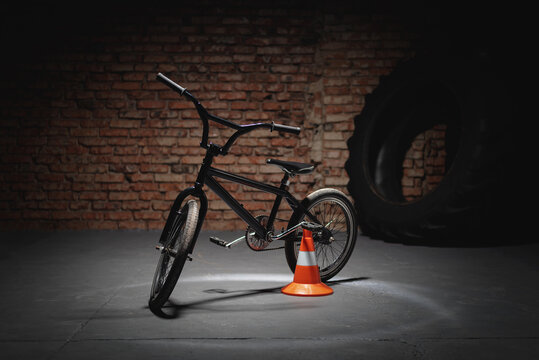 Black BMX bike on dark background.