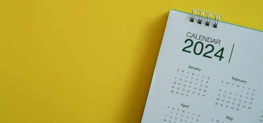 close up top view on calendar 2024 on yellow background with copy space for happy new year...