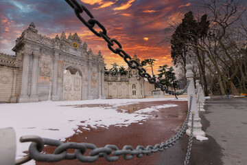 Sunset shot of closed gate leading former Ottoman Dolmabahce Palace, suited Ciragan Street,...