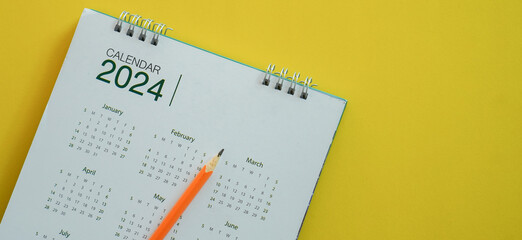 close up top view on white calendar 2024 with schedule of month and pencil to write or note and...