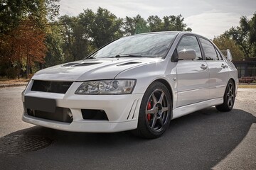 Fototapeta premium White car on a street background. Modern city sport car with spoiler wallpaper