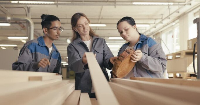 Appretices learning to assess wood with instructor in wood workshop