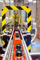 Fototapeta premium automation of manufacturing, bottling and labeling process of a red drink in an industrial factory