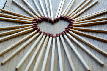 Heart from matches on the wooden background. Many long matches in heart form for men
