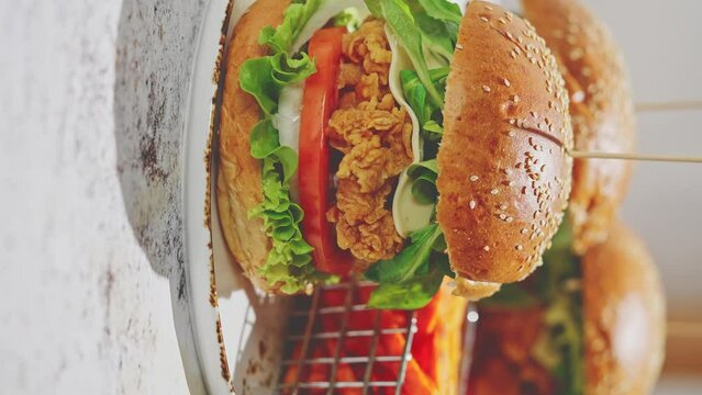 Crispy, breaded chicken double burgers with vegetables and drink, served with sweet potatoes