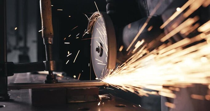 Craftsperson working with sparking cutting disc at workbench