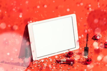 Digital tablet mockup and cosmetics on red background with confetti rain