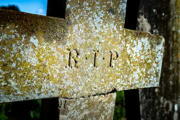 R.I.P Rest In Peace on a cross headstone in English church graveyard