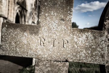 R.I.P Rest In Peace on a cross headstone in English church graveyard