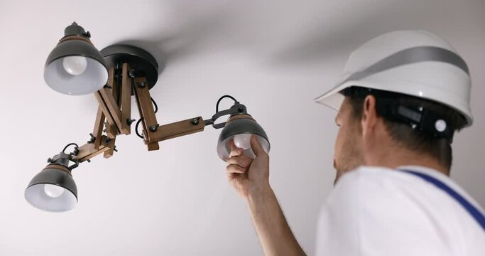 handyman services. electrician replace led light bulb in ceiling lamp at home