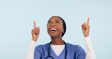 Smile, announcement and a nurse black woman pointing to space in studio on a blue background for healthcare. Medical, presentation and info with a happy young medicine professional showing mockup