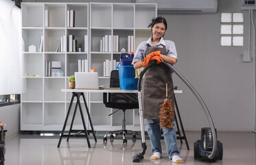 Fototapeta na wymiar Cleaning in the office Beautiful cleaning lady uses a mop and a vacuum cleaner to clean the floor and get rid of dust. Cleaning concept Housekeeping