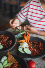 Hot plate or Sambal Gami is Traditional food from Indonesia. Served on plate with a bowl of rice and vegetables top view. Super hot and spicy food