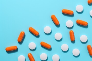 white orange pills on blue turquoise background. Vitamin and food supplements. Pharmaceutical business.