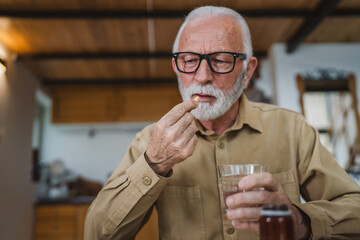 senior man caucasian grandfather take drug tablet drink painkillers