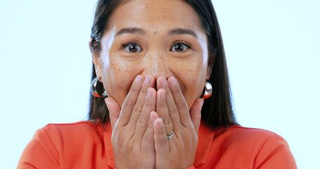 Portrait, wow and surprise with an asian woman in studio on a blue background to hear gossip or an...