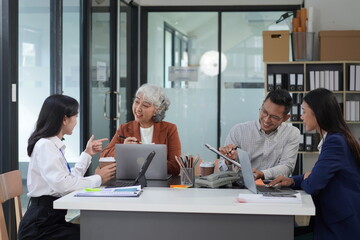 Four busy office workers listen to an African team leader take part in a group meeting in the office room. American supervisor gives advice to multi-ethnic company employees Consulting concept