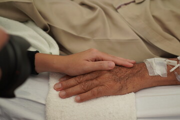 Asian family A daughter goes to visit her father in the hospital. Asian elderly man Sick and have health problems A female daughter is taking care of her father in a hospital bed. Massage for patients