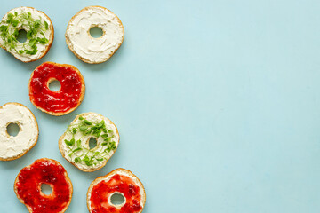 Fresh baked bagels with berry jam and cheese cream. Homemade bread background