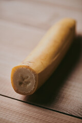 Close-up of peeled sliced banana on wooden table background