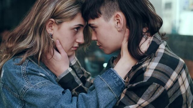 Lesbian girlfriends holding onto each other face to face