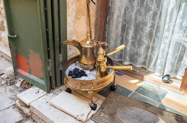 Real  Arabic coffee brewing over charcoal with the authentic copper kettle and fenjans in Nazareth old city in northern Israel