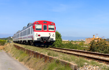 Fototapeta premium Train on railway. Spain regional commuter train in motion on railway. Spanish National Rail Network. Travel by train in European countries. Train against of mountains drive on railway
