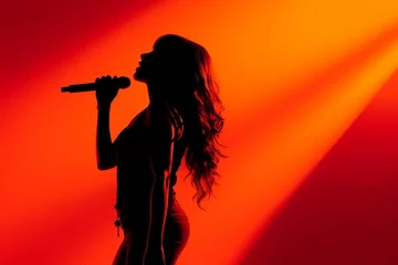Fotobehang silhouette of a female singer with a microphone on a red background © Viewvie