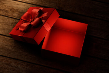 Red christmas gift on vintage wooden table from above. Open present box for xmas and new year holiday. Empty giftbox for product placement montage mockup background.