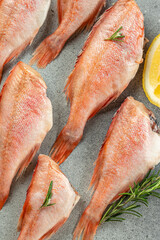 fish, red snapper with lemon, rosemary, salt on a light background. Healthy food concept. place for text, top view