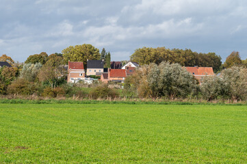 Fototapeta na wymiar Green farmland and residential houses at the Flemish countryside around Gooik, Belgium