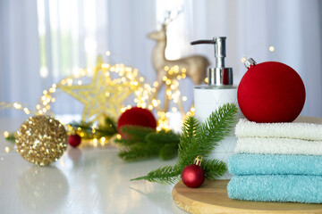 Fresh blue and white towels, fir branches, Christmas lights and toys on background. SPA or beauty salon concept. Laundry, washing or dry cleaning in Christmas or New Year variation. Copy space.
