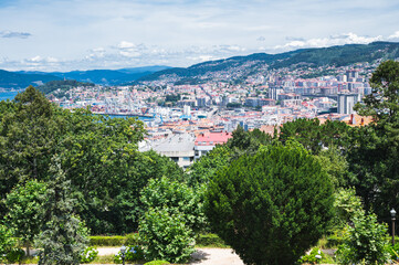 Fototapeta na wymiar The view from the hill in Parque Monte del Castro, park located on a hill in Vigo, the biggest city in Galicia Region, in the North of Spain. View of the sea, houses and trees, selective focus