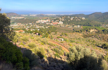 Obraz premium Houses at Gilet Town in mountains. Urbanization with houses and homes in mountains hills. View on city from mountain. Rural landscape with hills. Spain mountains landscape in Sierra Calderona park.