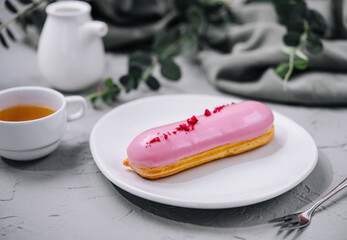 Eclairs with glaze on a white plate