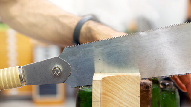 carpenter sawing a timber placed in a vise. Neck of a vihuela. - Powered by Adobe